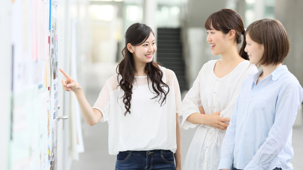 掲示物を指さして話す社員