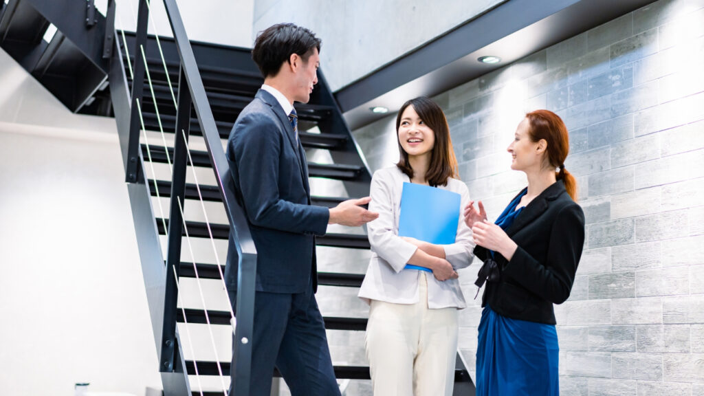資料を持って立ち話をする社員